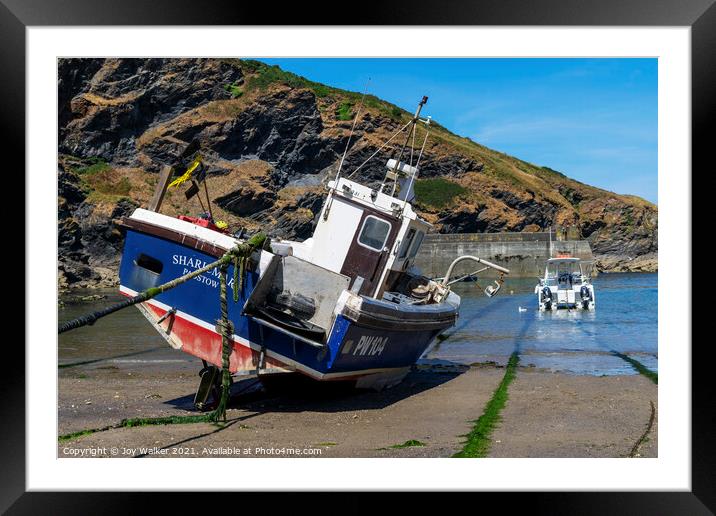 A fishing boat anchored in Port Isaac bay Framed Mounted Print by Joy Walker