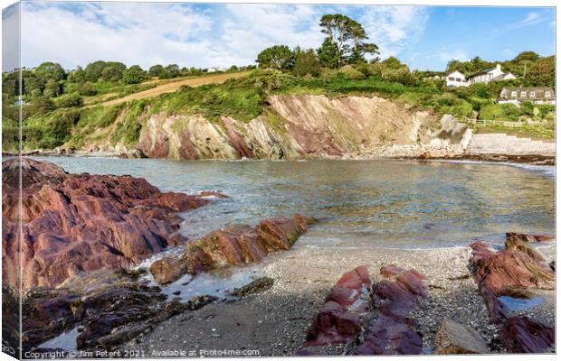 Talland Bay in the sunshine with the coloured red rocks Canvas Print by Jim Peters