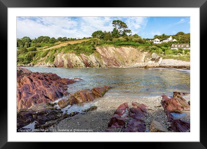 Talland Bay in the sunshine with the coloured red rocks Framed Mounted Print by Jim Peters