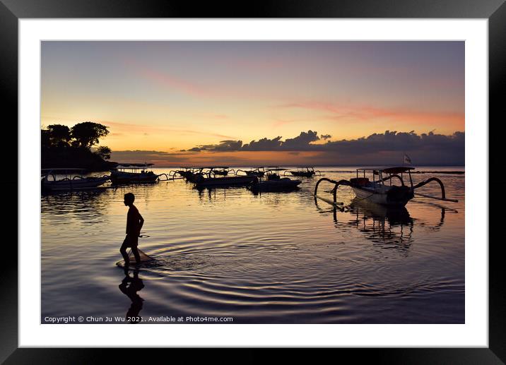 A boy walking through the sea water with sunset at background in Bali, Indonesia Framed Mounted Print by Chun Ju Wu