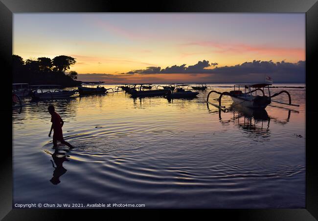 A boy walking through the sea water with sunset at background in Bali, Indonesia Framed Print by Chun Ju Wu