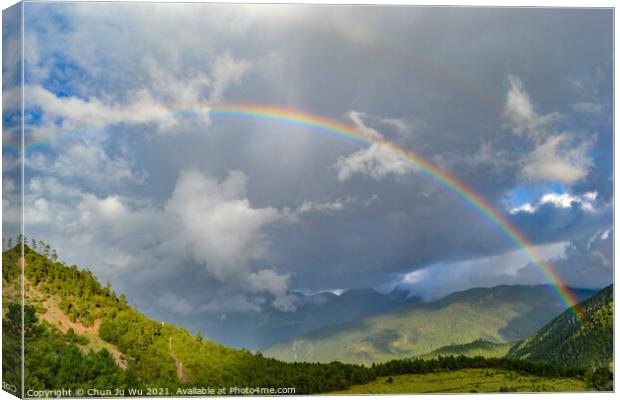 A rainbow among mountains in cloudy day Canvas Print by Chun Ju Wu