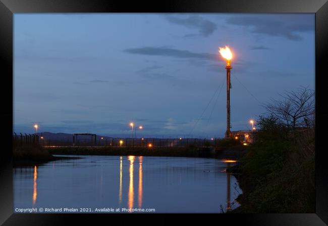 Gas flare over Water Framed Print by Richard Phelan