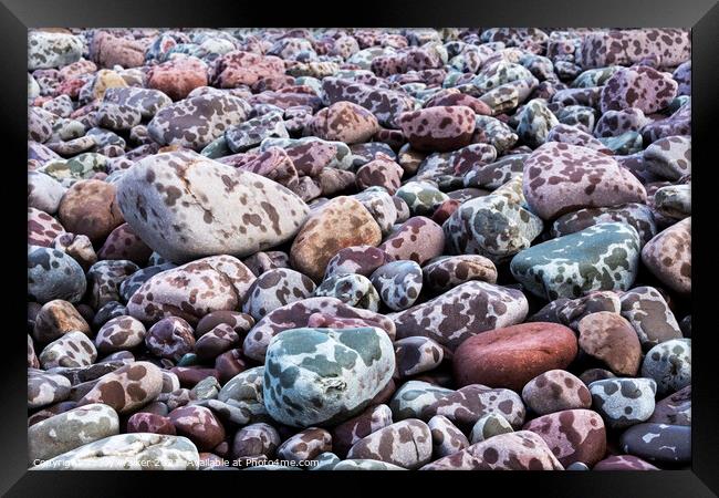 Pebbles on the seashore during a rain storm Framed Print by Joy Walker
