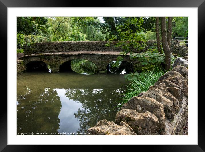A pedestrian bridge over the river in Castle Combe, Wiltshire, UK Framed Mounted Print by Joy Walker