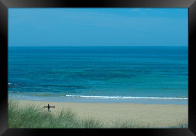 A lone surfer leaving the beach at Constantine Bay, Cornwall Framed Print by Frank Farrell