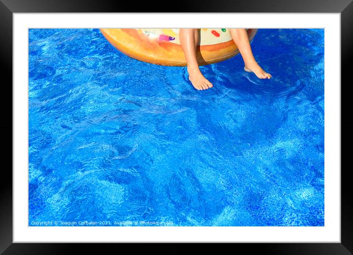 Crystal clear water pool where a child enjoys fun baths during t Framed Mounted Print by Joaquin Corbalan