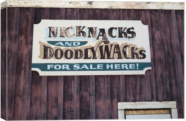 A faded tin sign on a wooden wall in Wyoming Canvas Print by Adrian Beese