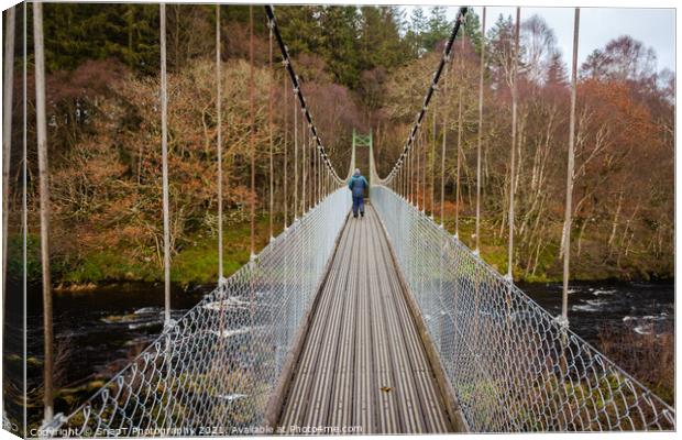 Man walking over an old wooden suspension bridge across a river in Scotland Canvas Print by SnapT Photography