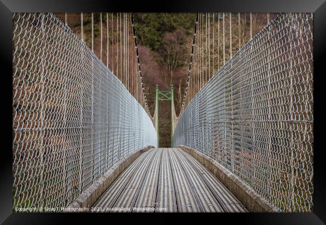 View across a wooden suspension bridge leading into a forest woodland Framed Print by SnapT Photography