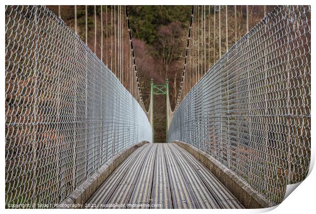 View across a wooden suspension bridge leading into a forest woodland Print by SnapT Photography