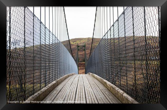 View across a wooden suspension bridge in the Scottish highlands Framed Print by SnapT Photography