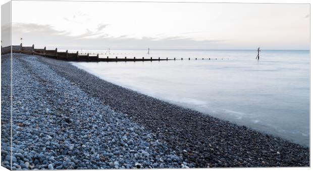 Groynes stretch out from the pebbly beach at Sheringham Canvas Print by Jason Wells