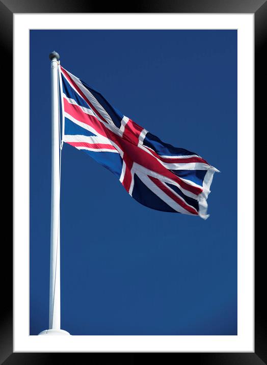 Union Jack flying against blue sky Framed Mounted Print by Neil Overy