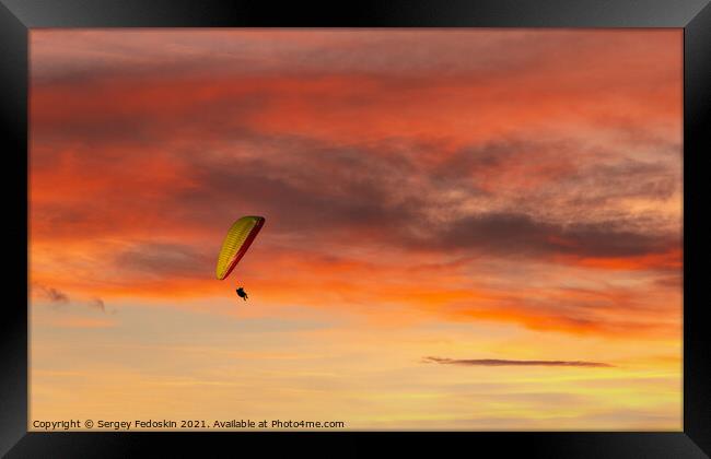 Paraglider flying in the beautiful sky against the background of Framed Print by Sergey Fedoskin