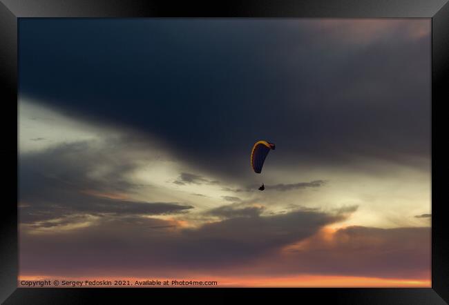 Paraglider flying in the beautiful sky against the background of Framed Print by Sergey Fedoskin