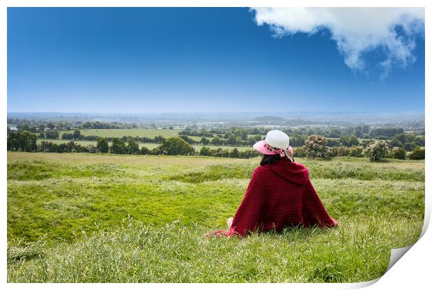 Woman sitting down in grassy farm fields while looking at the ho Print by Thomas Baker