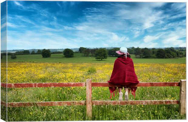 Woman sitting on fence while looking out at the farmland   Canvas Print by Thomas Baker