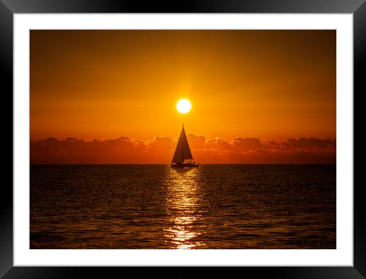 A lone sailboat sailing in the dawn sun Framed Mounted Print by Vicen Photo