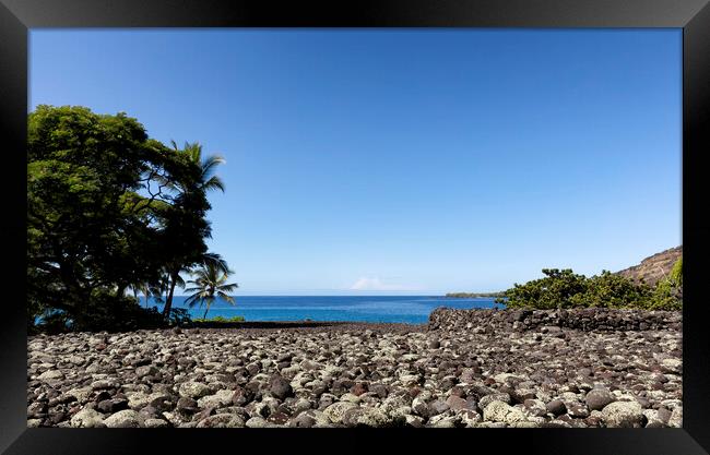 Front view of a rock beach in Hawaii with ocean and sky in backg Framed Print by Thomas Baker