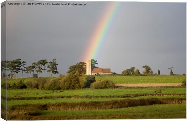 Rainbow shining on Ramsholt church Canvas Print by Ian Murray
