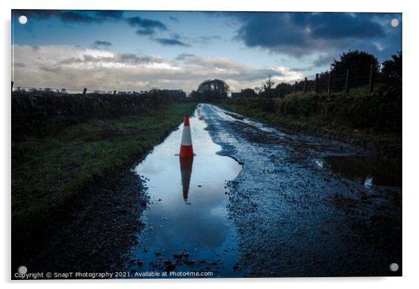 A red traffic cone reflecting a pot hole containing a pool of water on a road Acrylic by SnapT Photography