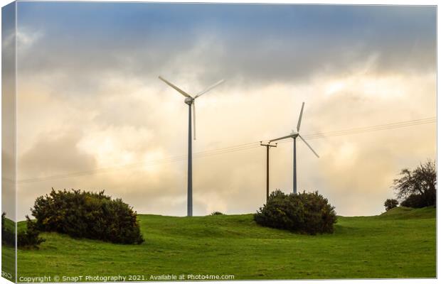 Wind turbines in a green field on the horizon on a cloudy day at sunset Canvas Print by SnapT Photography