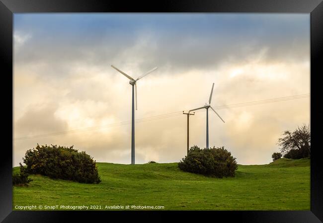 Wind turbines in a green field on the horizon on a cloudy day at sunset Framed Print by SnapT Photography