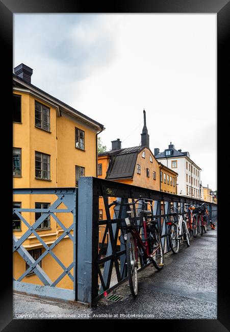 Bicycles parked in the street with colorful houses in Sodermalm  Framed Print by Juan Jimenez