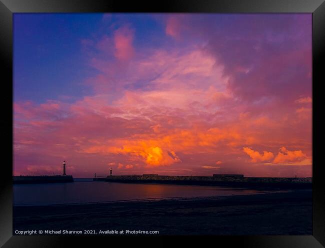 Colourful sky over the piers at Whitby in North Yo Framed Print by Michael Shannon