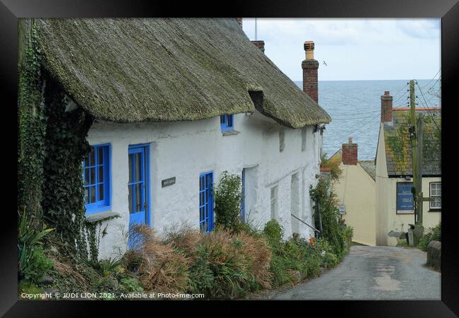 Thatched cottages by the sea Framed Print by JUDI LION