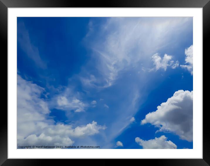 Fluffy white cloud shapes at blue sky. Framed Mounted Print by Hanif Setiawan