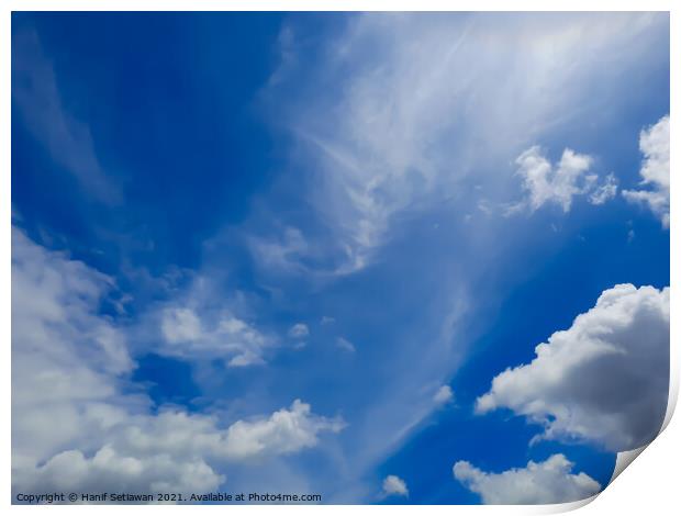 Fluffy white cloud shapes at blue sky. Print by Hanif Setiawan
