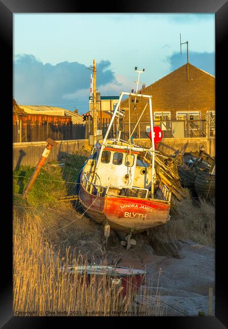 Small fishing boat stuck on the mud Framed Print by Clive Wells