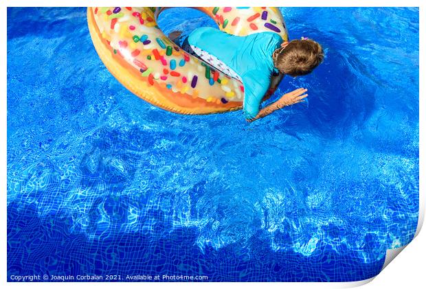 6-year-old boy bathing in a transparent pool playing with a larg Print by Joaquin Corbalan