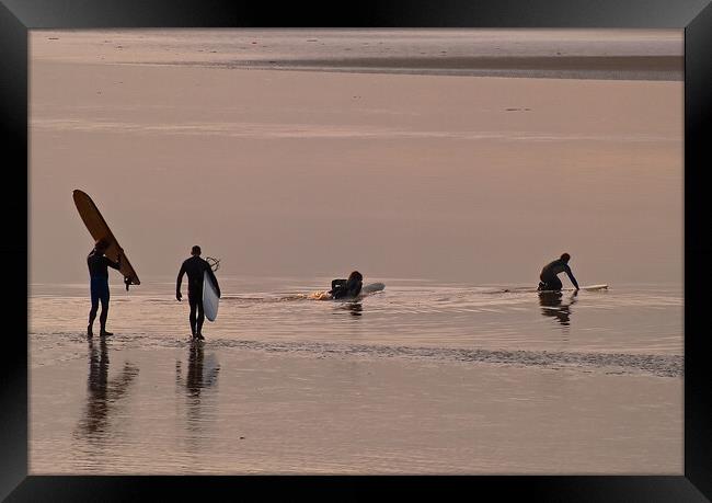 Surfers walking out to water with surfboards Framed Print by mark humpage