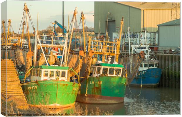 Fishing boats at low tide Canvas Print by Clive Wells