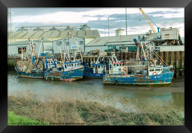 Line up of fishing boats Framed Print by Clive Wells