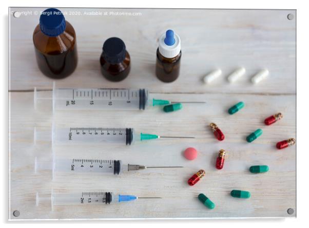 Syringes and capsules, medical ampoules and tablets on a white wooden table. Acrylic by Sergii Petruk