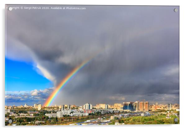 A bright rainbow in the sky above city houses after a thunderstorm separates thunderclouds from the clear sky. Acrylic by Sergii Petruk