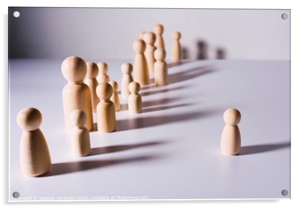 Social distance symbolized with wooden figures isolated from each other on white background. Acrylic by Joaquin Corbalan