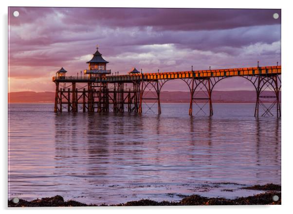 Clevedon Pier at sunset with a Pinkish hue in the sky and reflecting onto the sea Acrylic by Rory Hailes