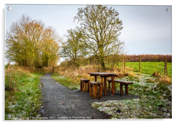 Wooden table and chairs at a seating area on a countryside trail in winter Acrylic by SnapT Photography