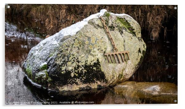 A bronze rake attached to a large boulder by a chain, covered by snow in winter Acrylic by SnapT Photography