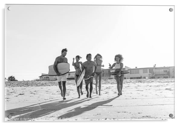 Friends in swimwear running carrying bodyboards on beach Acrylic by Spotmatik 