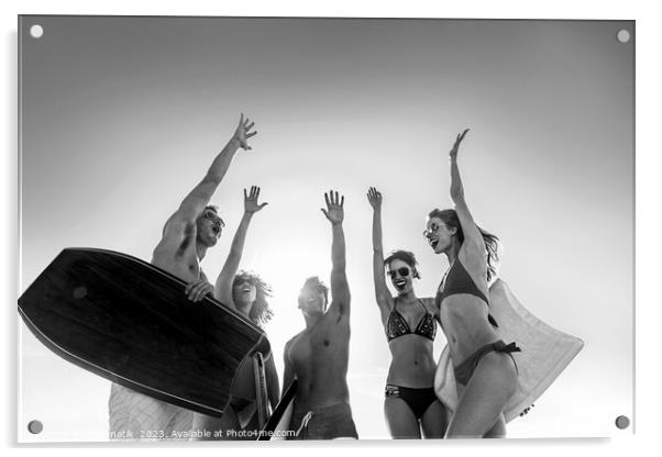 Friends in swimwear carrying bodyboards celebrating fun activity Acrylic by Spotmatik 