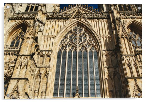 Gothic architecture detail of a cathedral's facade, featuring a large stained glass window and ornate stone carvings under clear skies in York, North Yorkshire, England. Acrylic by Man And Life