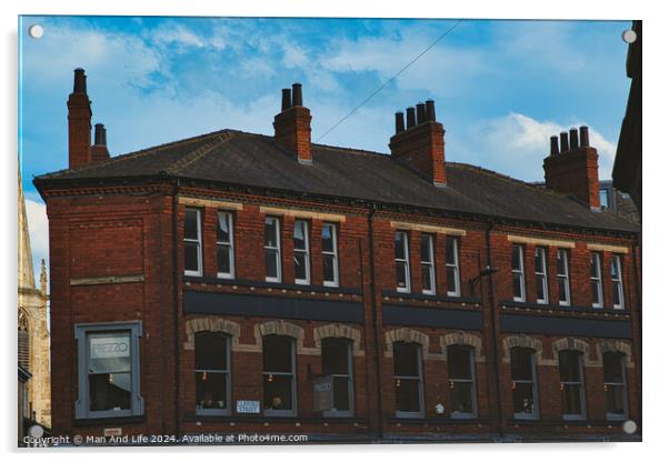 Traditional red brick building with multiple chimneys against a blue sky with light clouds, showcasing classic urban architecture in York, North Yorkshire, England. Acrylic by Man And Life