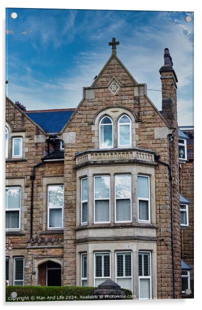 Victorian-style stone building with a gabled roof and bay windows under a blue sky with clouds, showcasing classic architectural details and craftsmanship in Harrogate, North Yorkshire. Acrylic by Man And Life