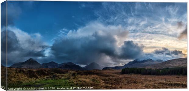 The sun setting to the right of a panorama of the red and black Cuillin Hills. Canvas Print by Richard Smith